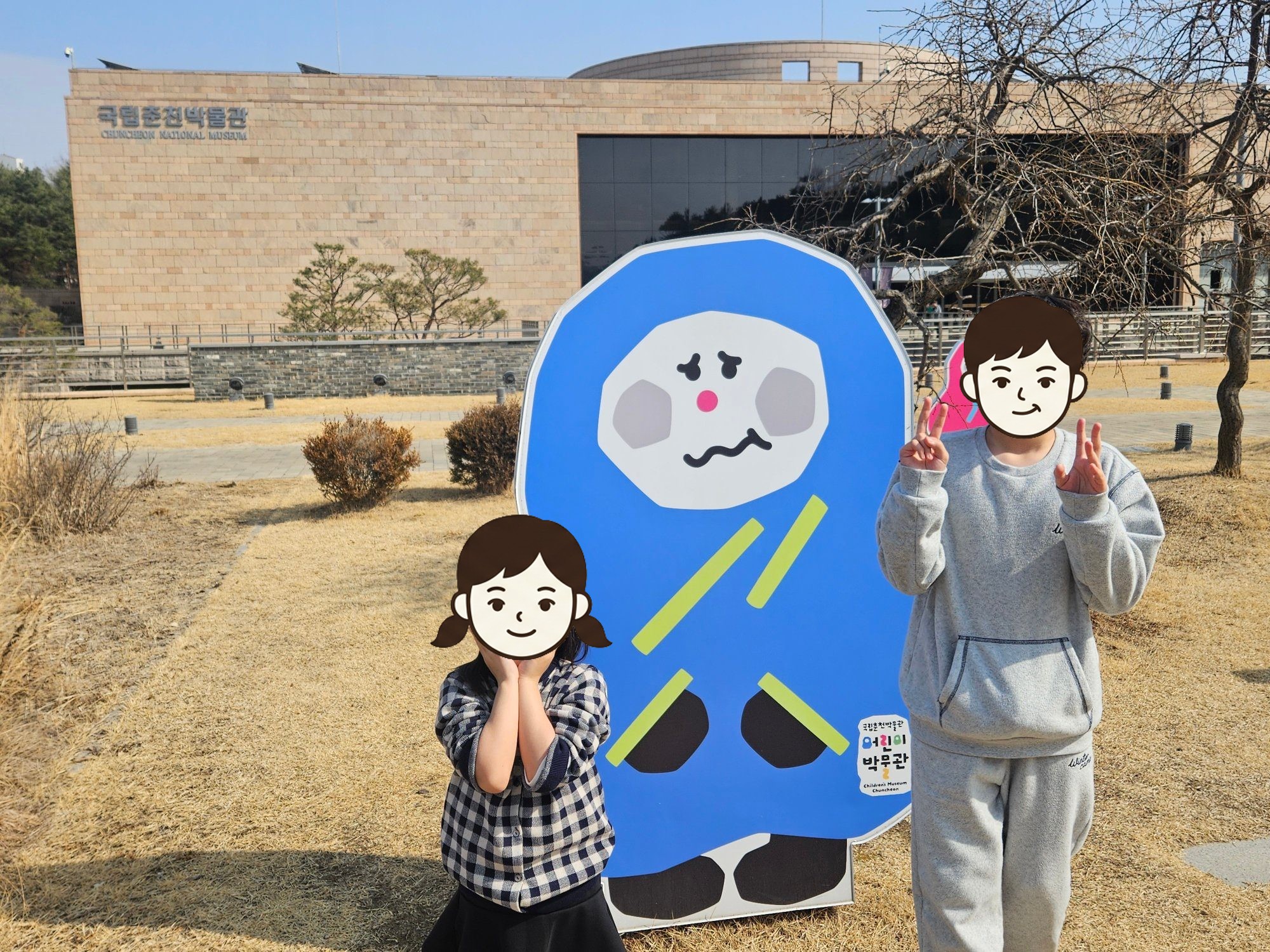 국립춘천박물관 앞 나한 캐릭터 입간판 옆에 선 첫째와 둘째