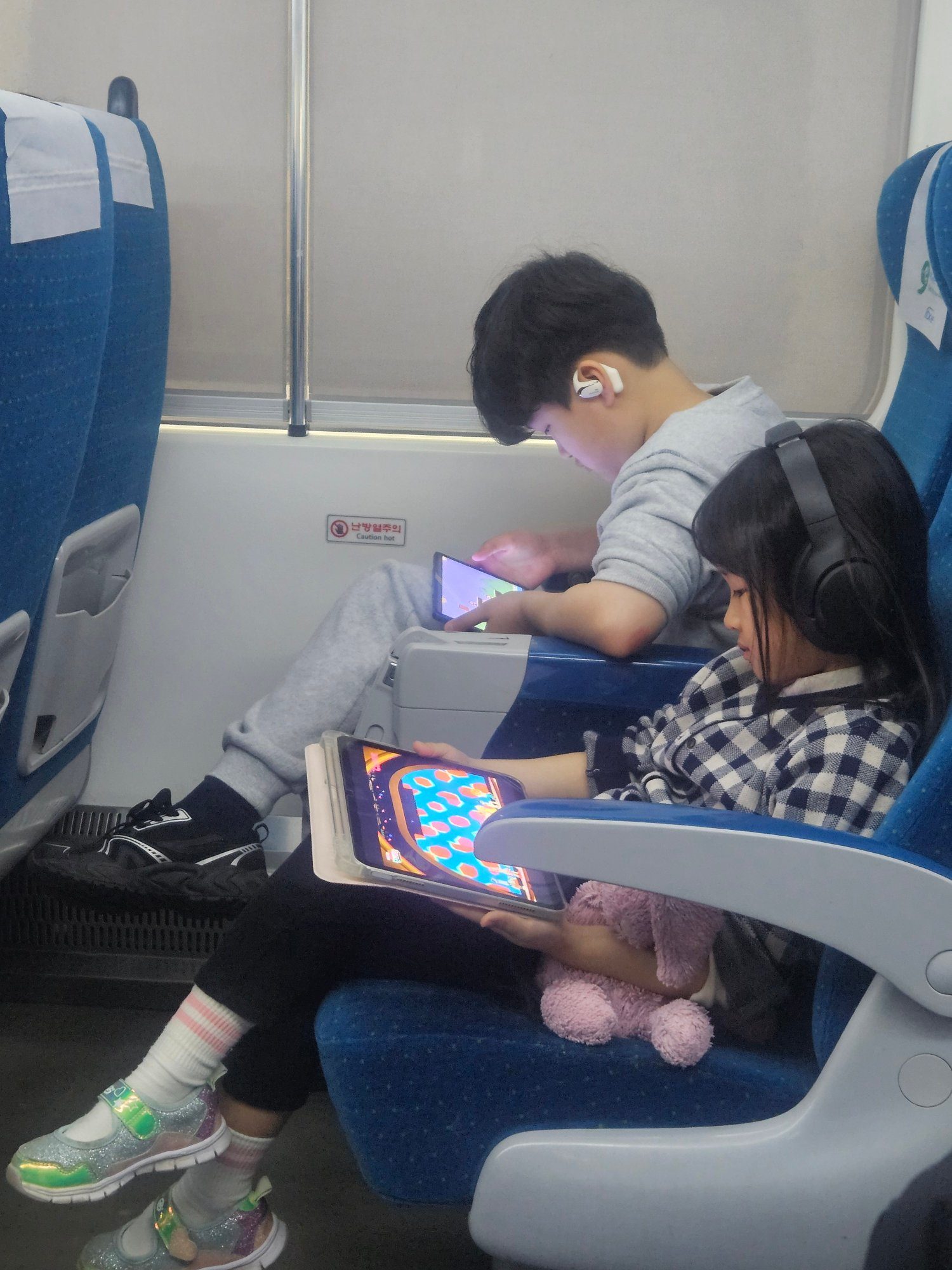돌아오는 기차에서 태블릿을 보는 첫째와 둘째