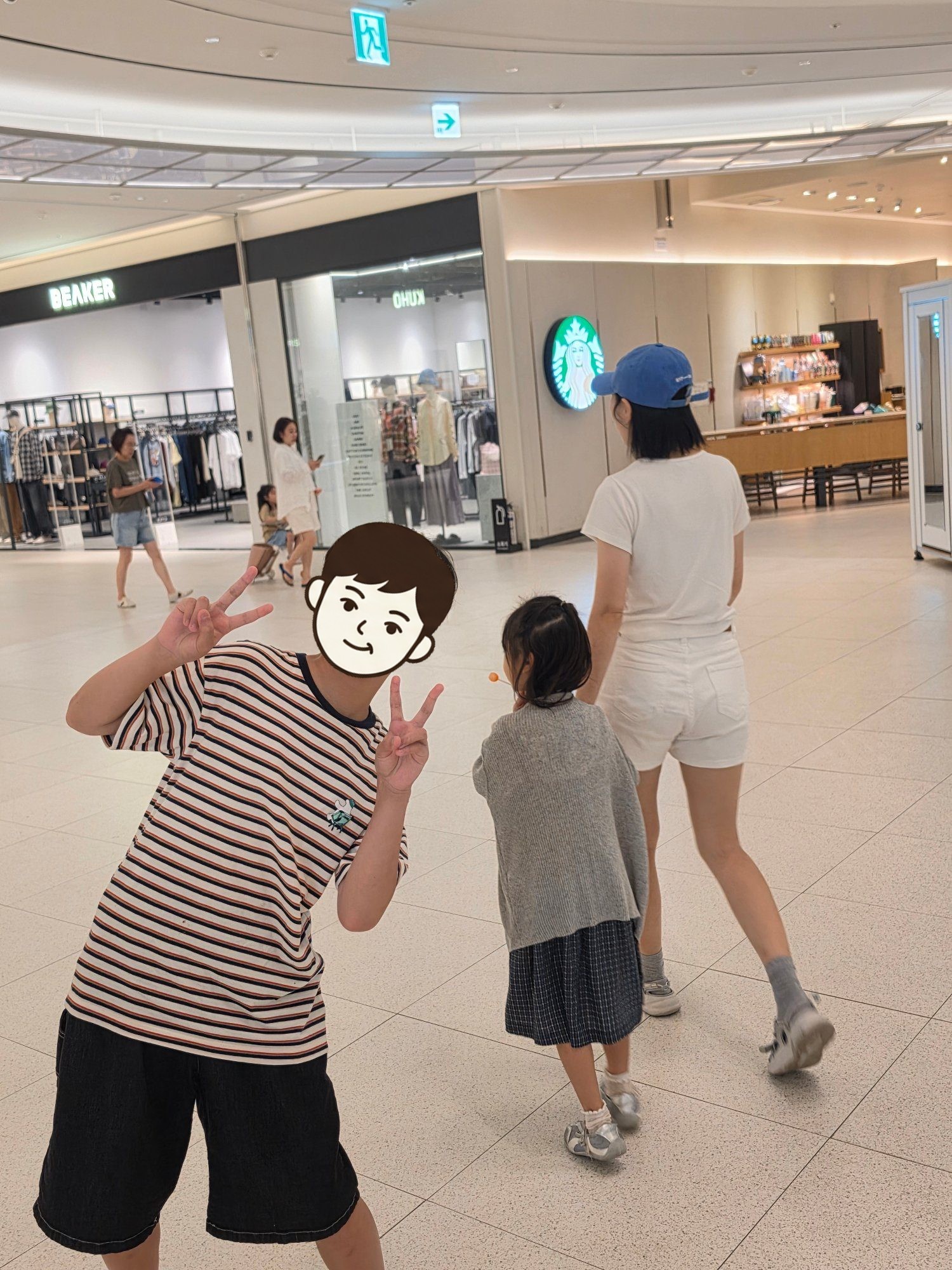 아울렛 복도에서 브이를 하는 첫째와 앞서 걷는 엄마, 둘째