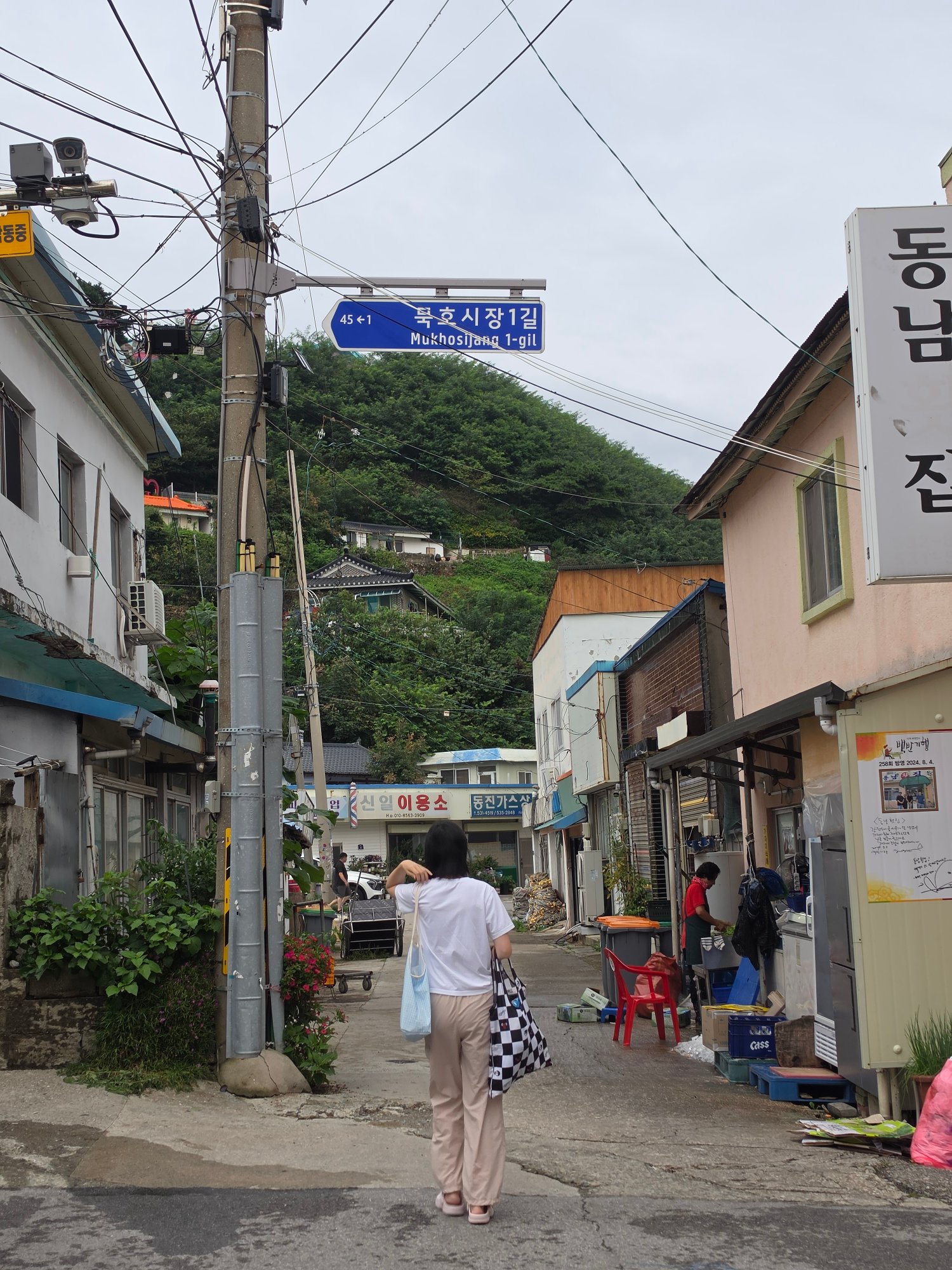 봉투를 들고 묵호시장 골목을 걷는 엄마의 뒷모습
