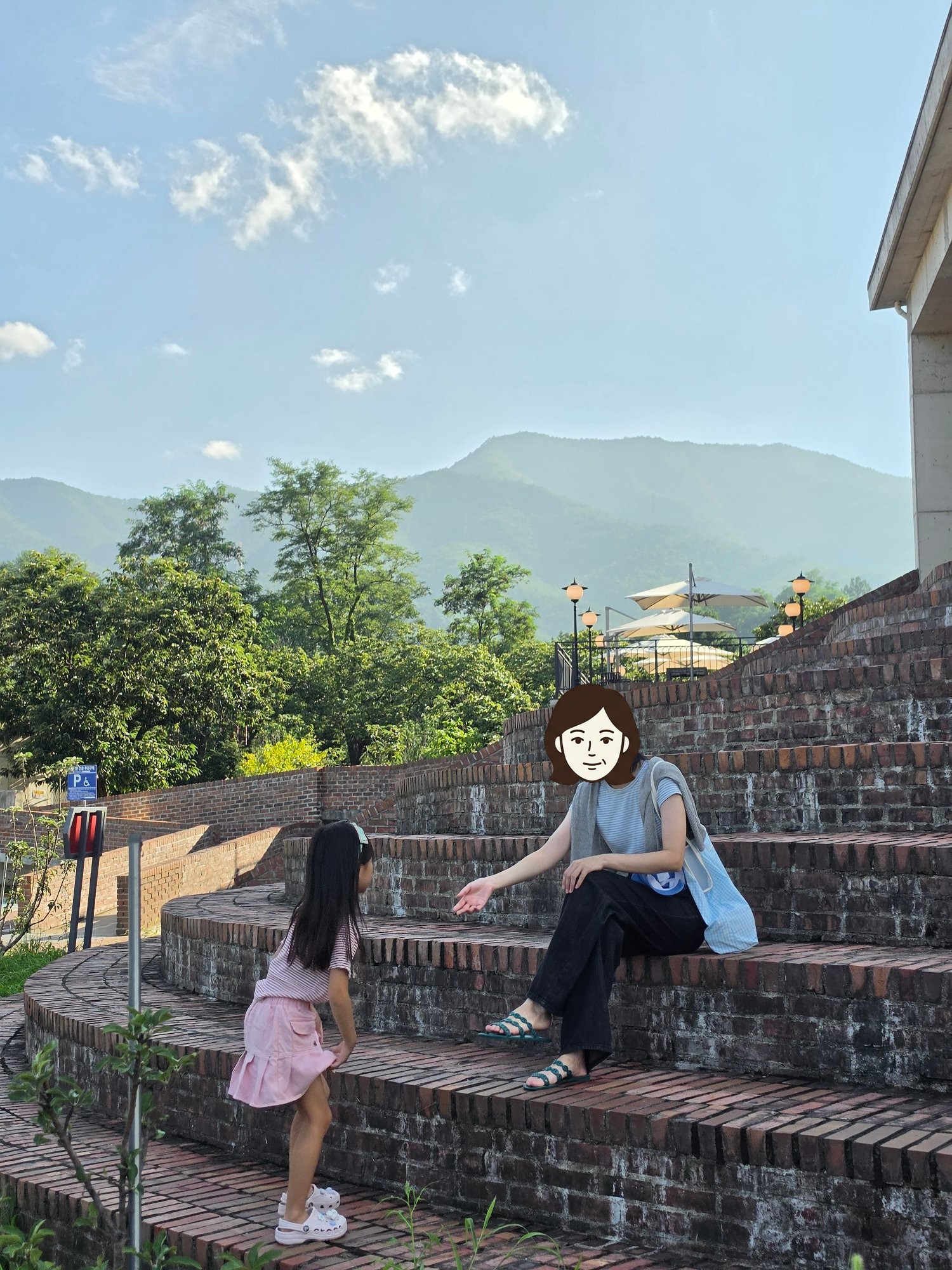 벽돌 계단에서 손을 맞잡으려는 엄마와 모아