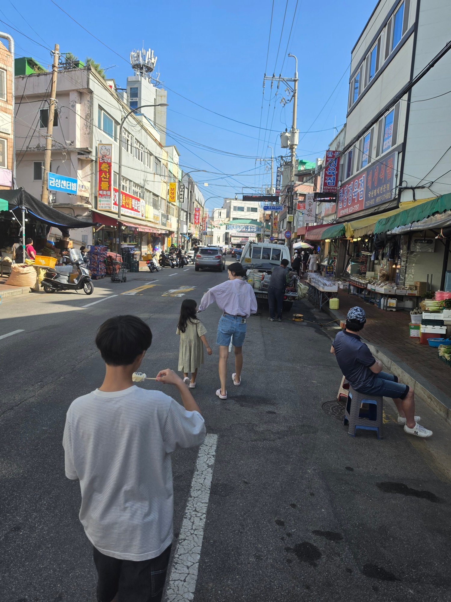 시장 골목을 걸어가는 첫째와 가족