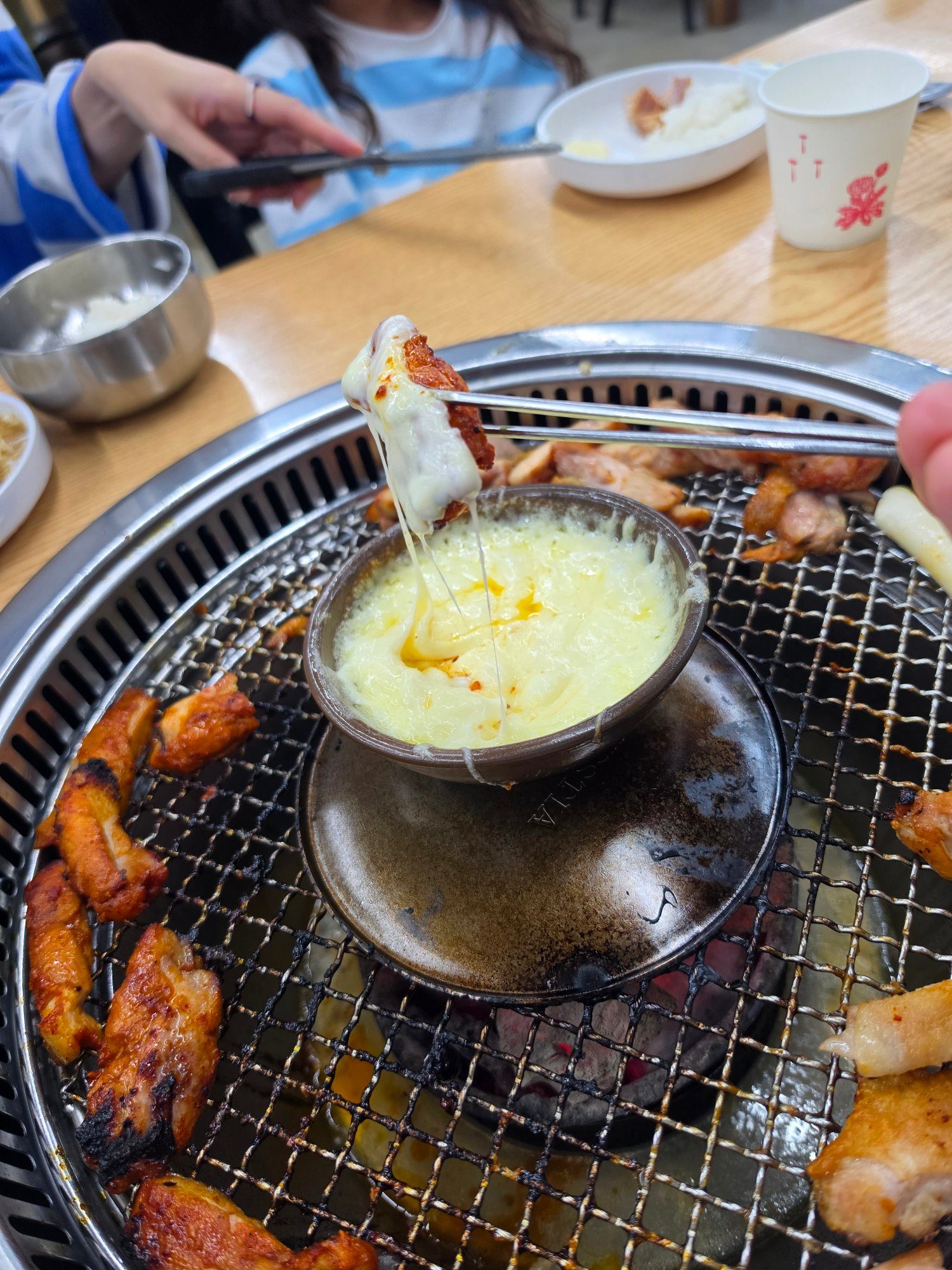 닭갈비를 치즈퐁듀에 찍는 모습