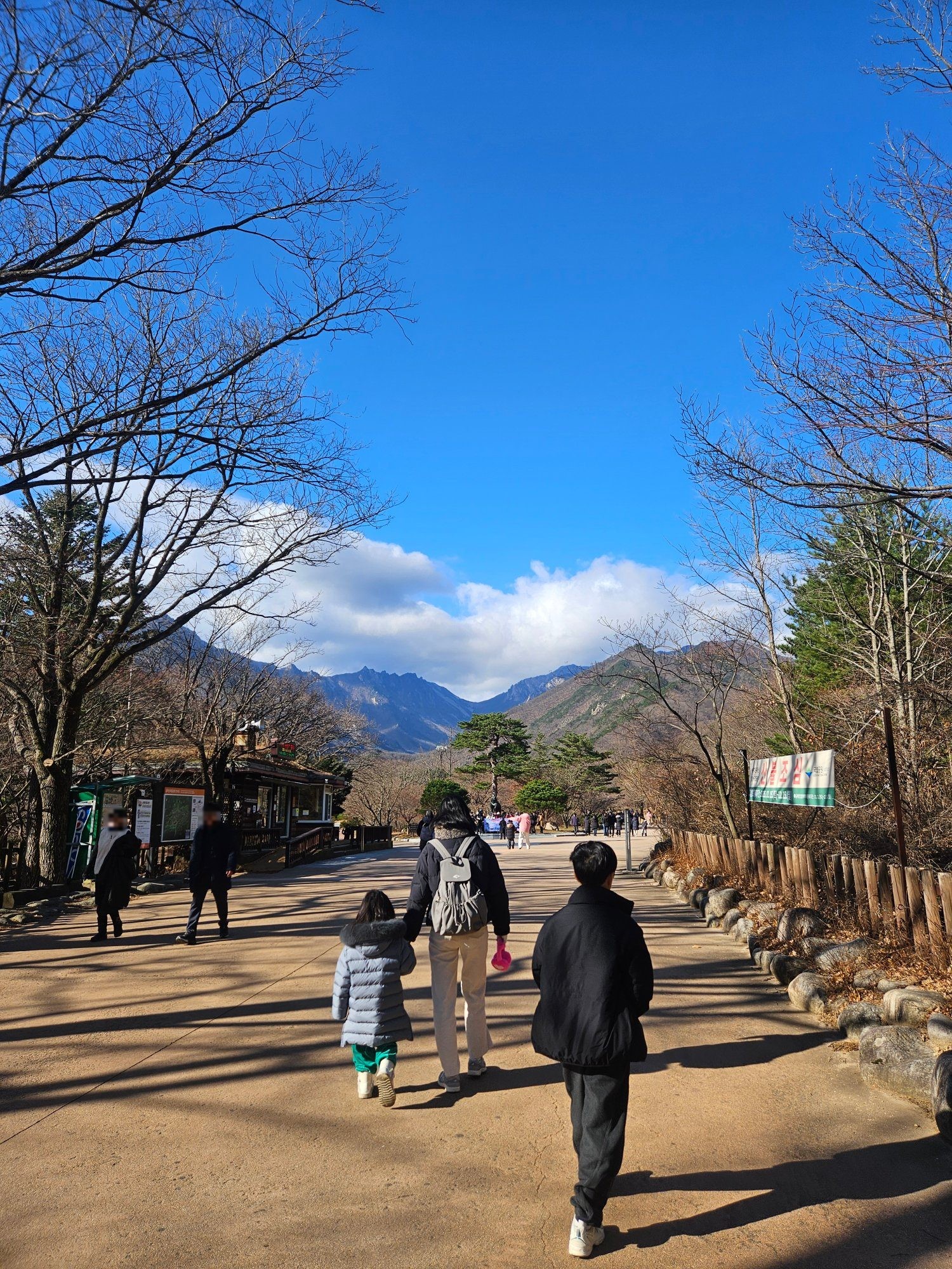 파란 하늘 아래 설악산 산책로를 걸어가는 가족
